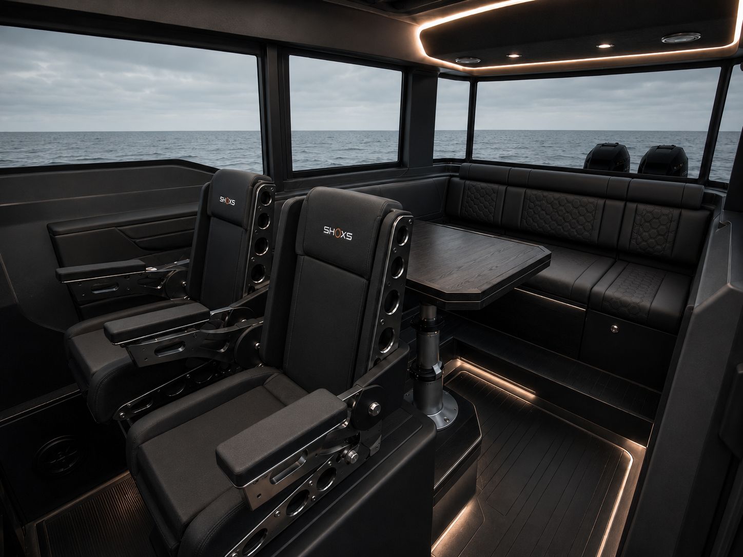 Main pilothouse of the Revenant 369 Blackline SAR with twin SHOXS shock-mitigation seats, a wraparound honeycomb-stitched lounge, dinette table, and panoramic windows over open ocean.