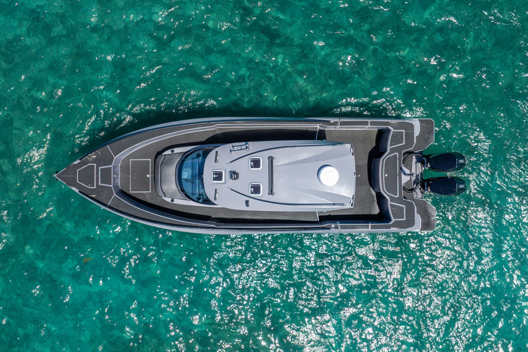 Top-down aerial of the CERE 369 Signature at rest over crystal-clear turquoise water.