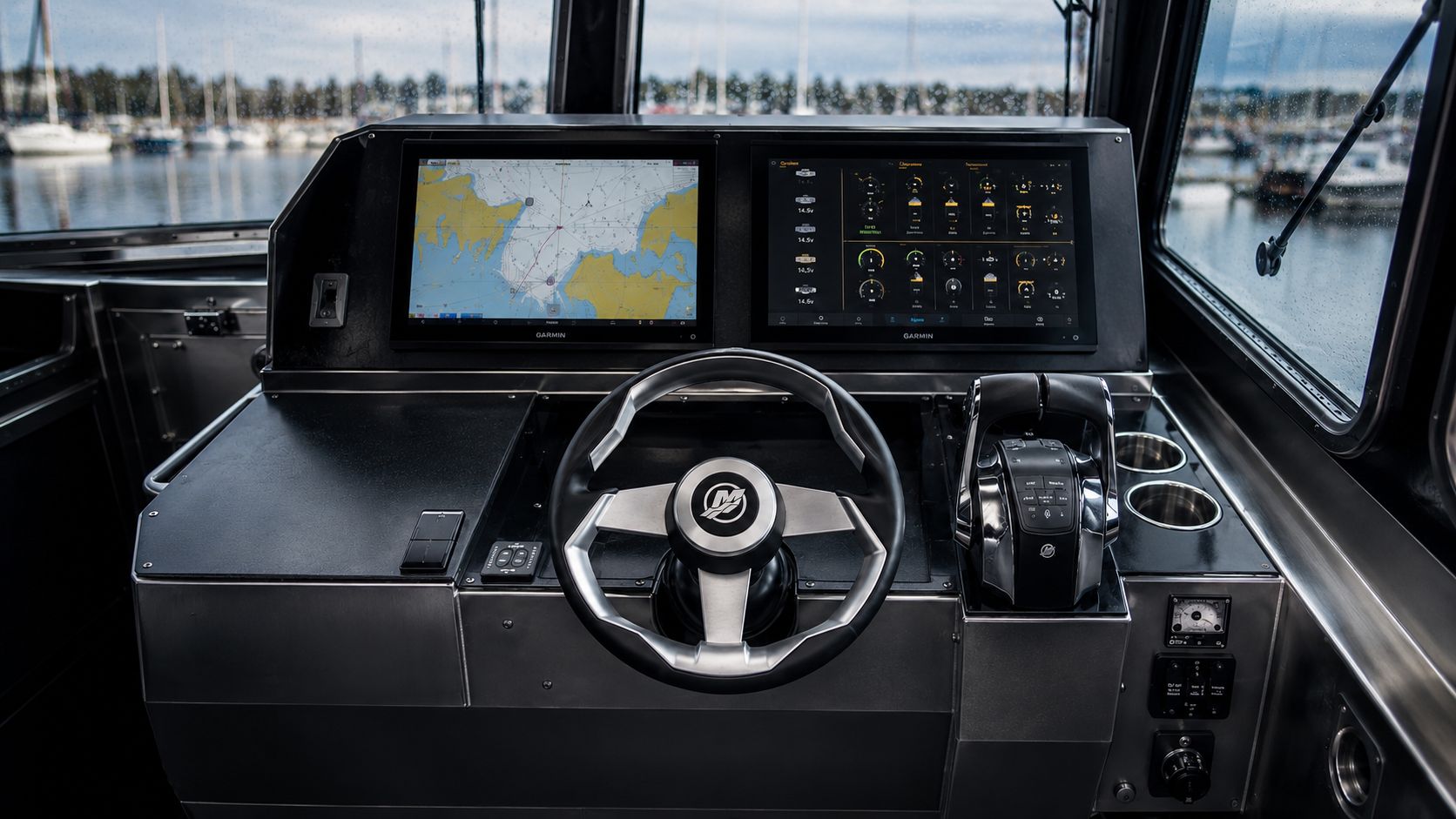 LC-259 M.U.L.E. helm shown on a clear day with twin Garmin displays, Mercury wheel, joystick throttle, and panoramic marina view through the pilothouse windows.