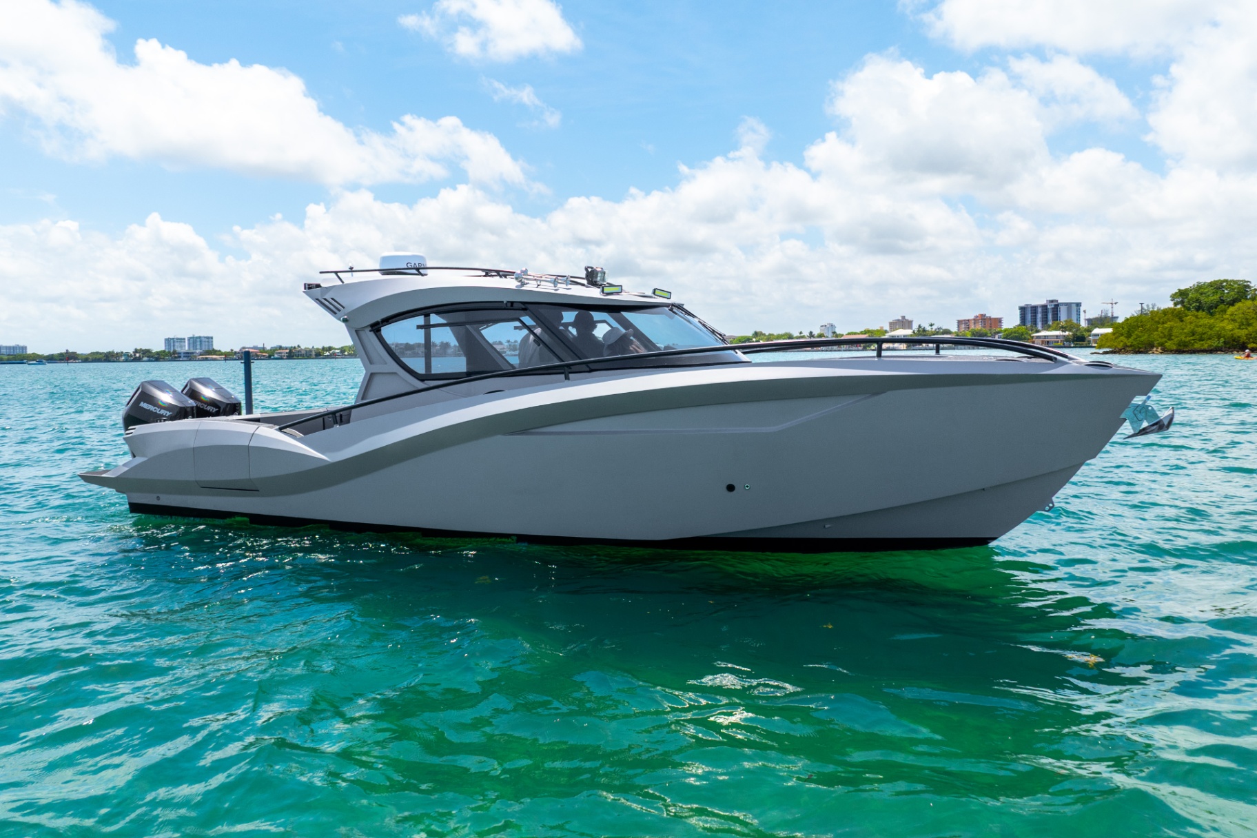 Full starboard profile of the CERE 369 Signature at rest in calm water under bright clouds.