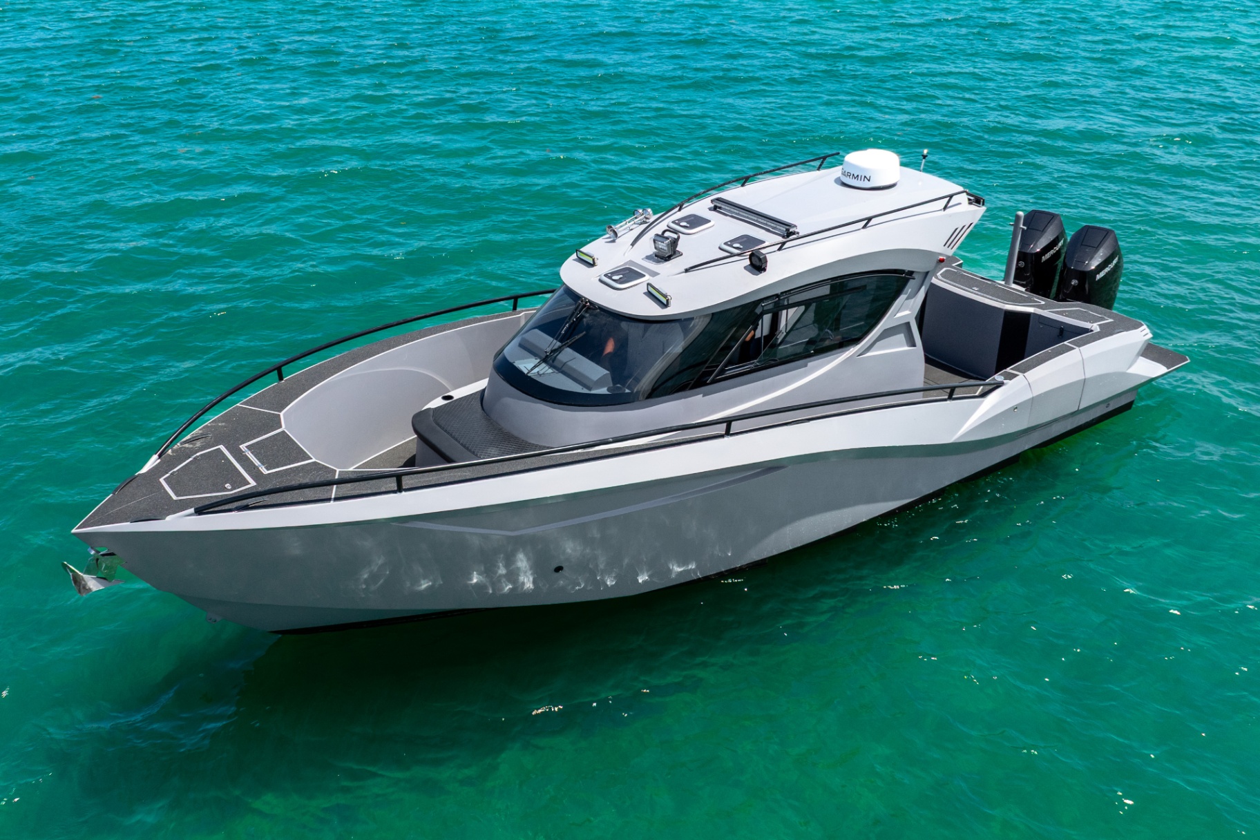 Elevated 3/4 view of the CERE 369 Signature at rest over turquoise water, hardtop electronics visible.