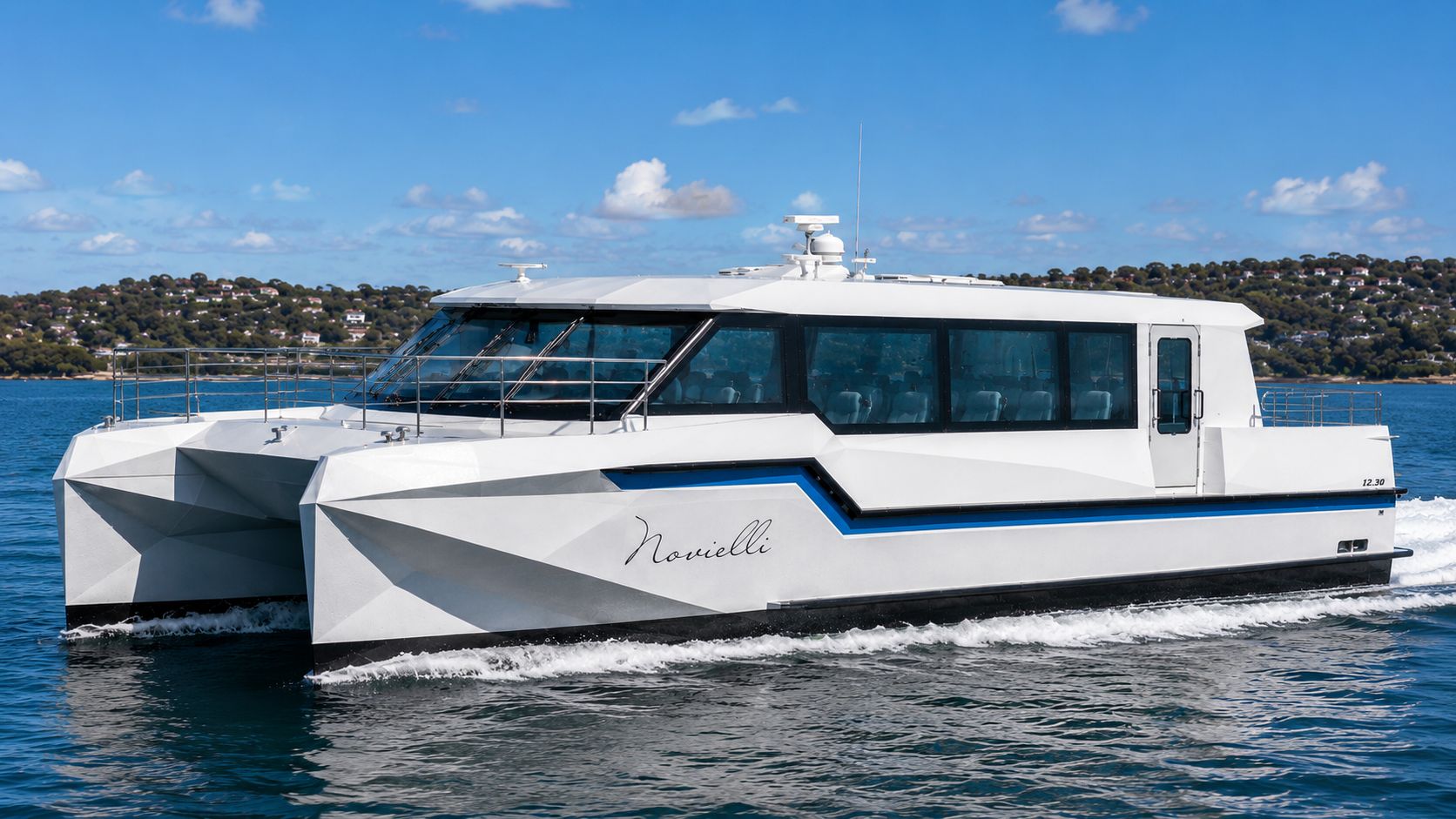 Novielli Coastline 509 white faceted-hull passenger ferry catamaran with enclosed cabin underway on blue coastal water.