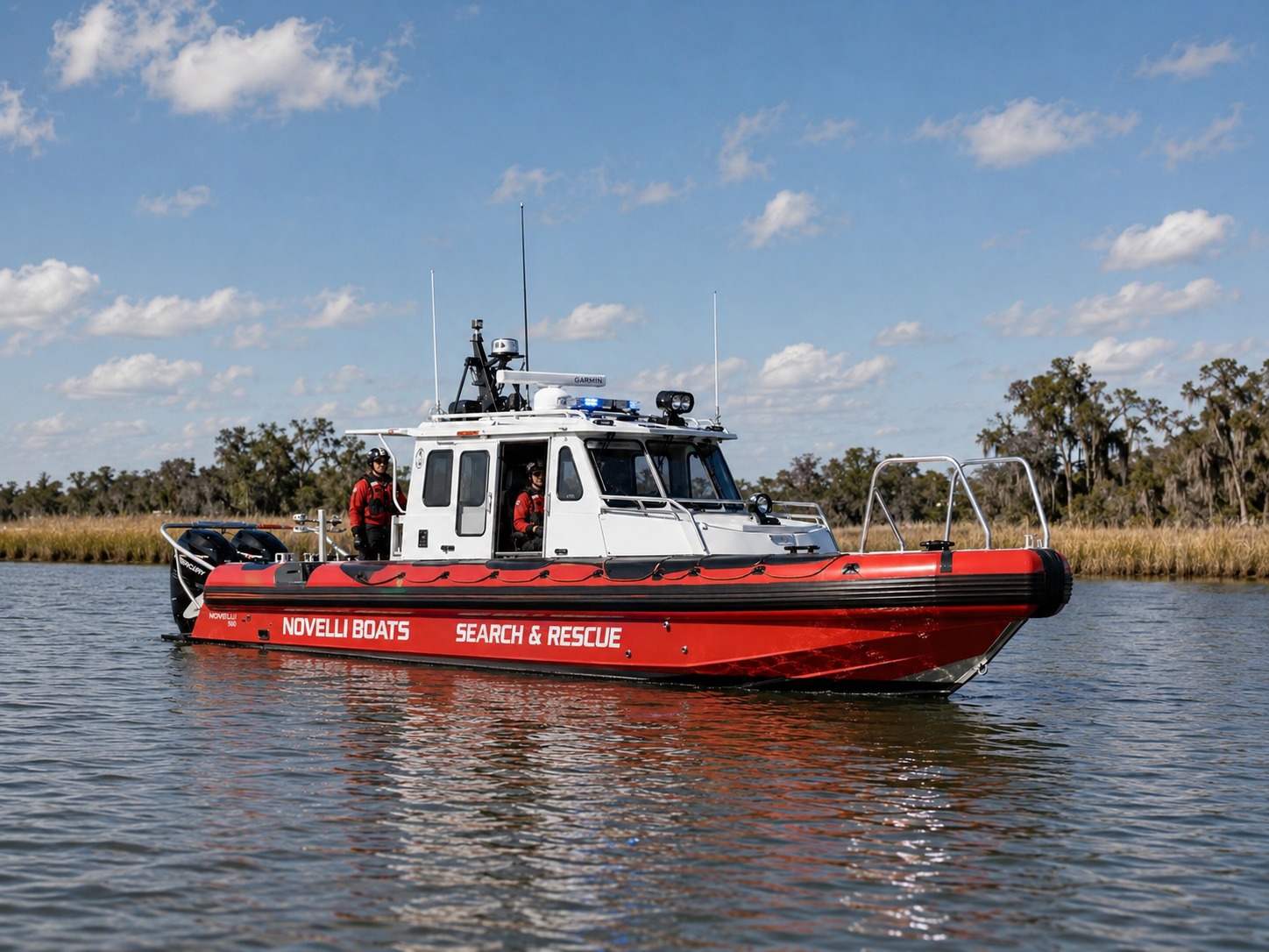 Novielli red Search & Rescue RIB with white pilothouse, Garmin radar, and twin Mercury outboards idling on a calm marsh waterway with crew aboard.